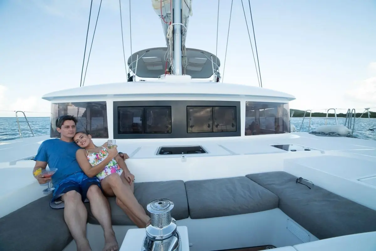 A couple sitting at the cockpit of catamaran Azulla