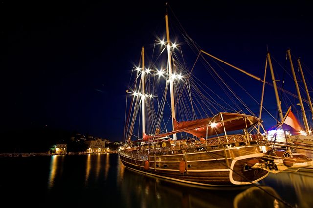 Motor-sailer docked at night