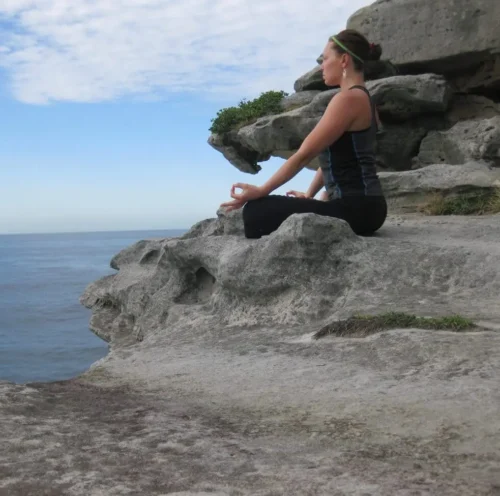 A lady doing yoga while on a luxury yacht charter