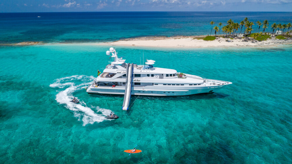 Motor Yacht At Last anchored in the Bahamas with guests enjoying the water toys.