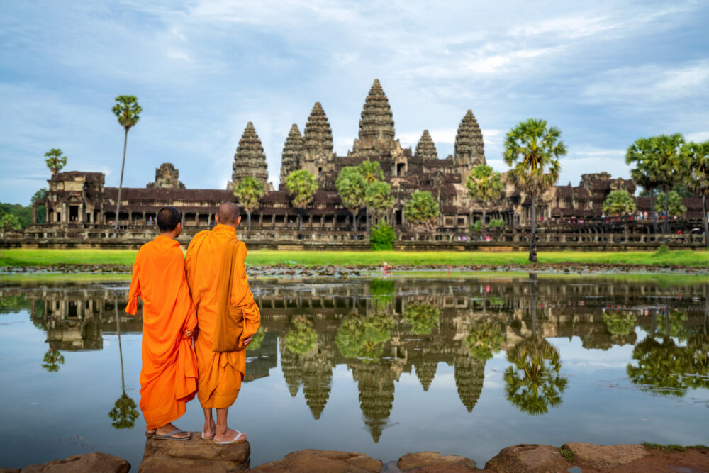 luxury yacht charters worldwide monks in orange robes in front of a temple in Angkor Wat Cambodia