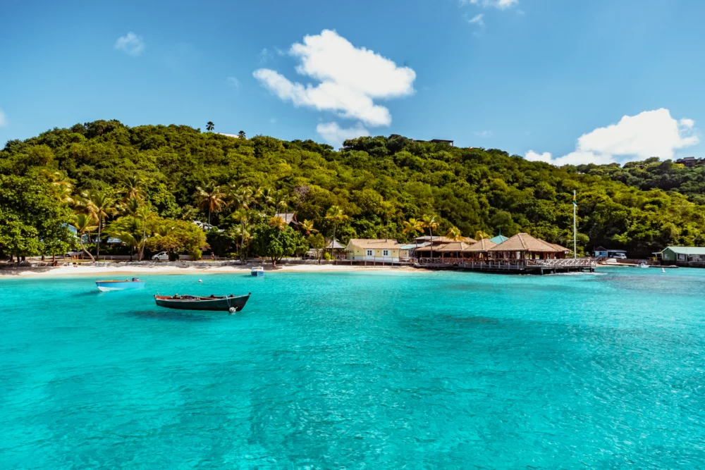 a boat in shallow waters in Mustique - grenadines sailing itinerary.