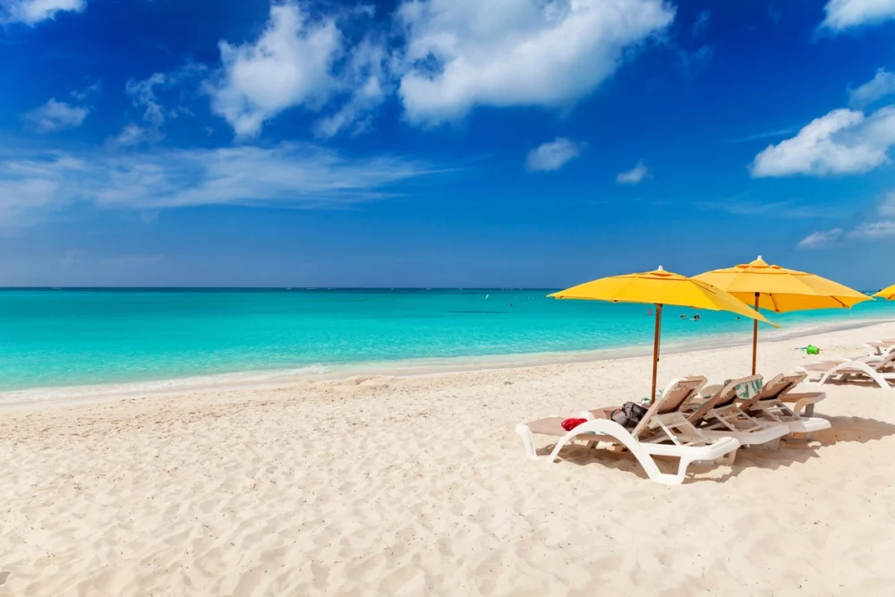 two people under umbrellas at Grace Bay Beach