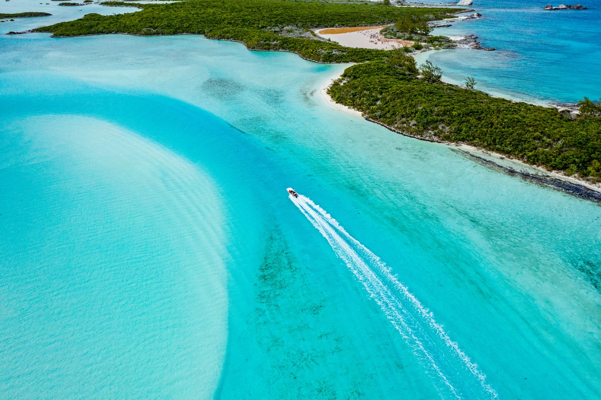 a speedboat cruising through the waters near an island
