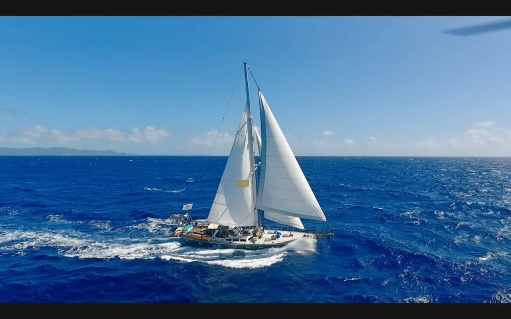 A sleek KAI Sailboat glides across the sparkling Caribbean Sea, epitomizing the adventure and serenity offered by Caribbean sailing charters
