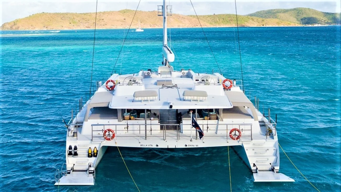 View from the stern of the Bella Vita, a spacious sailing catamaran, anchored in the clear blue waters of the Caribbean, perfect for an all-inclusive yacht charter.