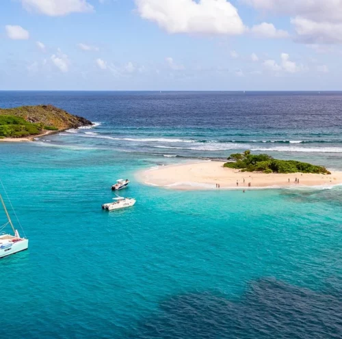 Aerial view of a catamaran yacht anchored at Ssandy Spit Island in the turquoise waters of the British Virgin Islands, ideal for those looking to charter a yacht in the Caribbean.
