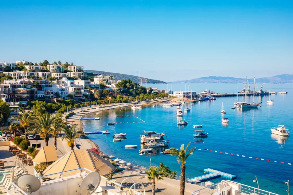 A view of Bodrum Beach in Turkey with sailboats docked in the clear blue water, a good place for a private crewed charter
