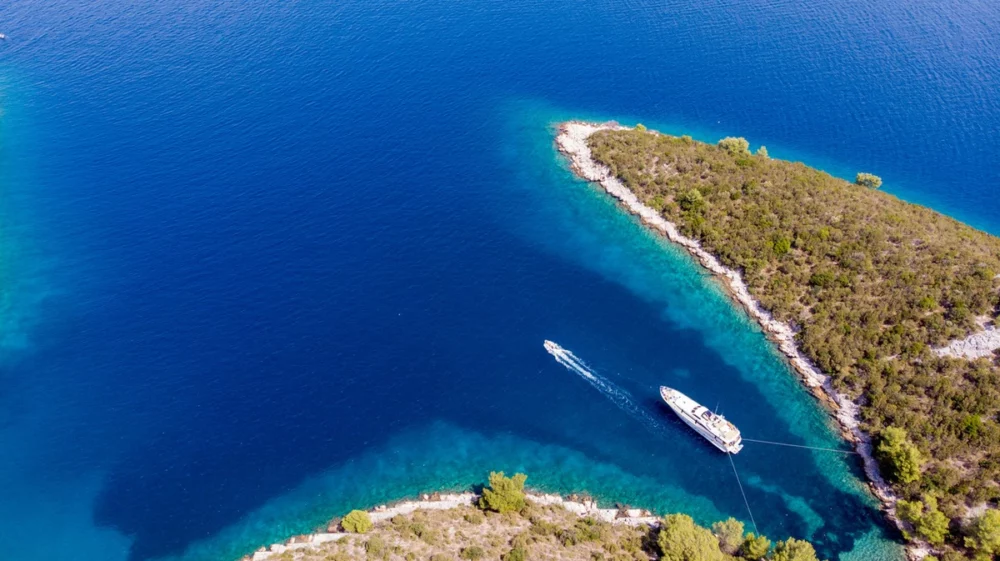 A luxurious yacht anchored in Bora Bora, navigating the deep blue sea.