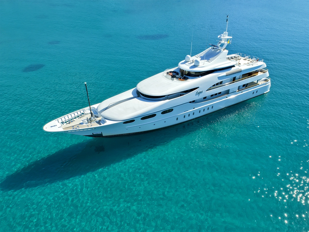 The Capri I motor yacht floats in clear blue waters. Its sleek design and spacious decks make it perfect for a private cruise. luxury yacht rental