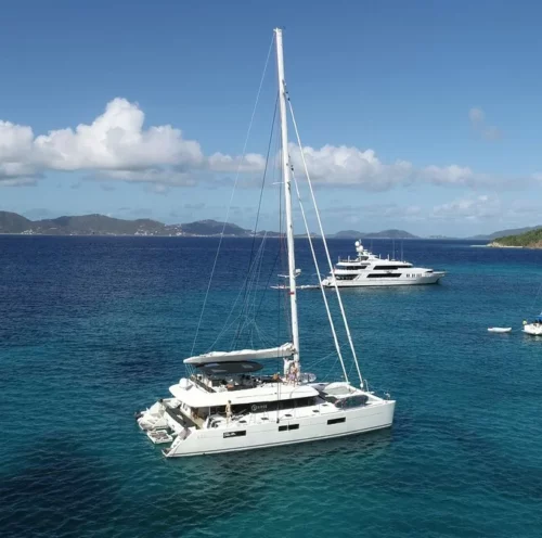 The Eclipse catamaran is anchored in clear turquoise waters with a small island in the background. The boat is perfect for families and groups of friends looking for an affordable yacht charter experience.