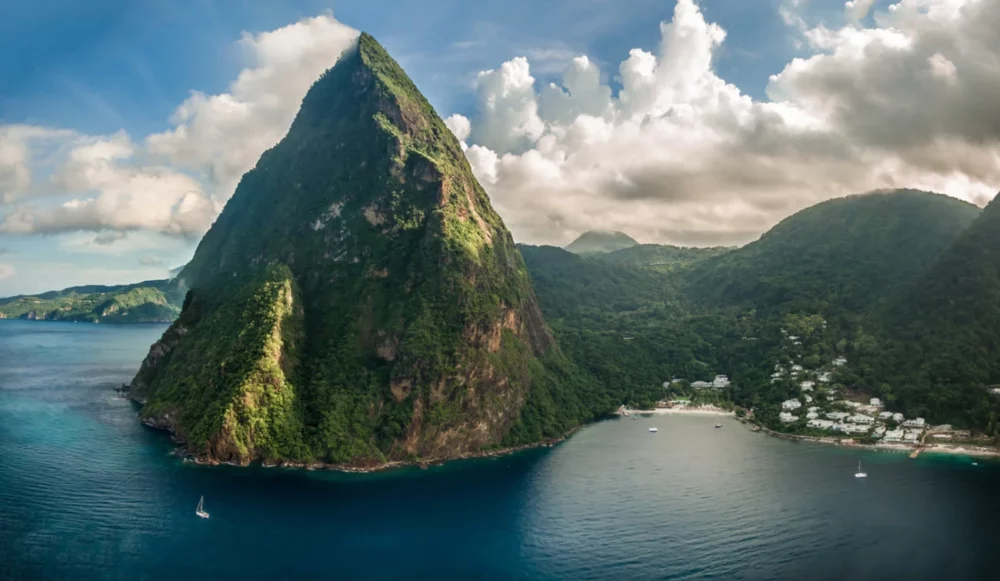 Scenic view of the Pitons in St. Lucia, with lush green mountains and the calm Caribbean Sea.