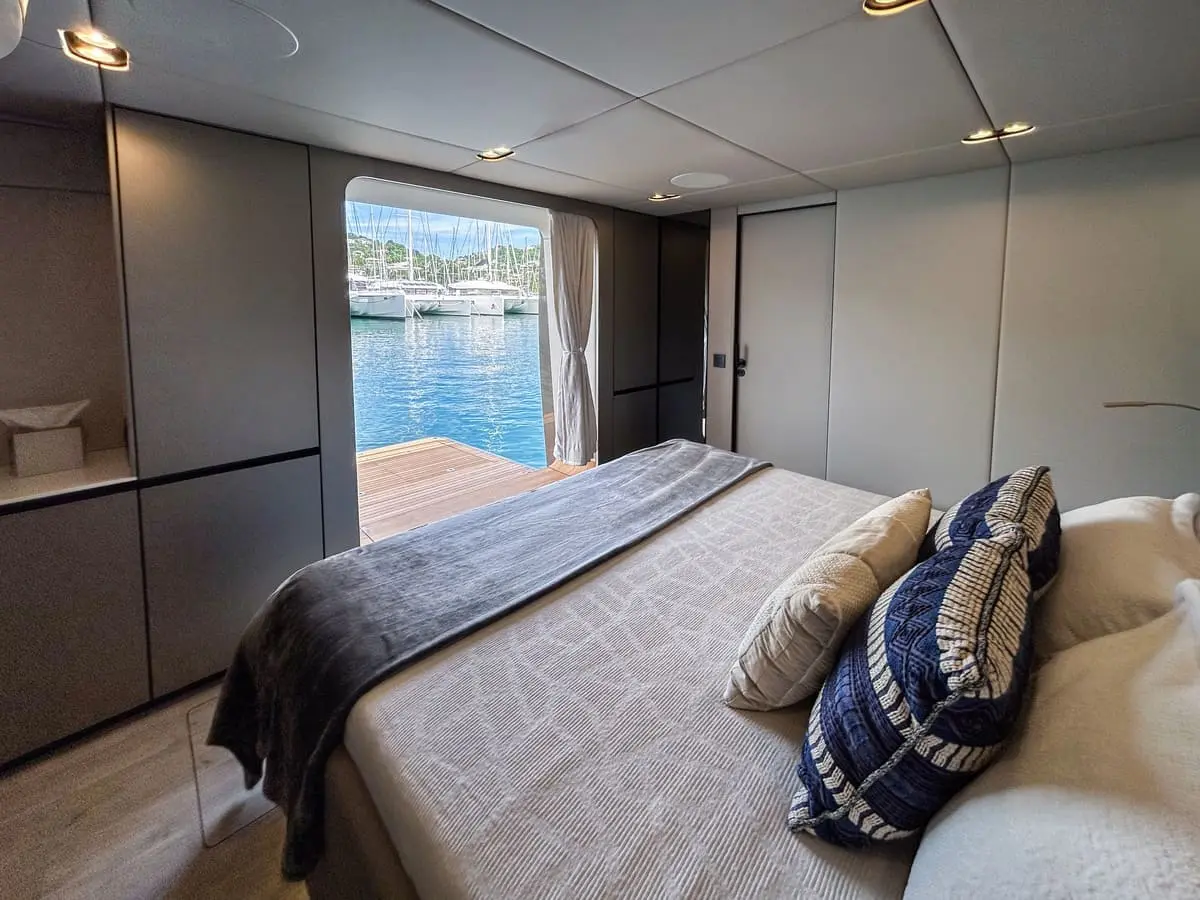 Elegant cabin interior of the Nauti Nickel power catamaran and a private sliding door leading to a deck with stunning water views.